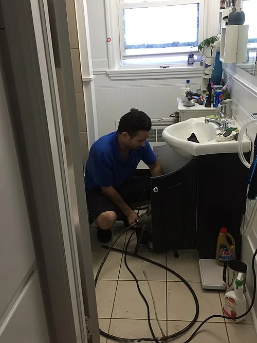 Professional plumber repairing a sink — real photograph