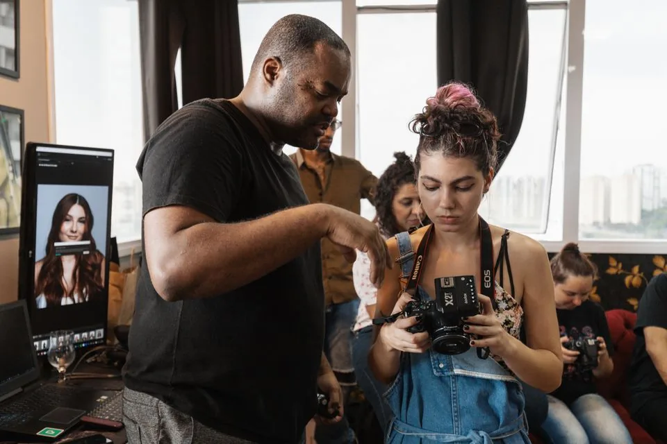 Instructor guiding participants in a hands-on photography workshop — real photograph